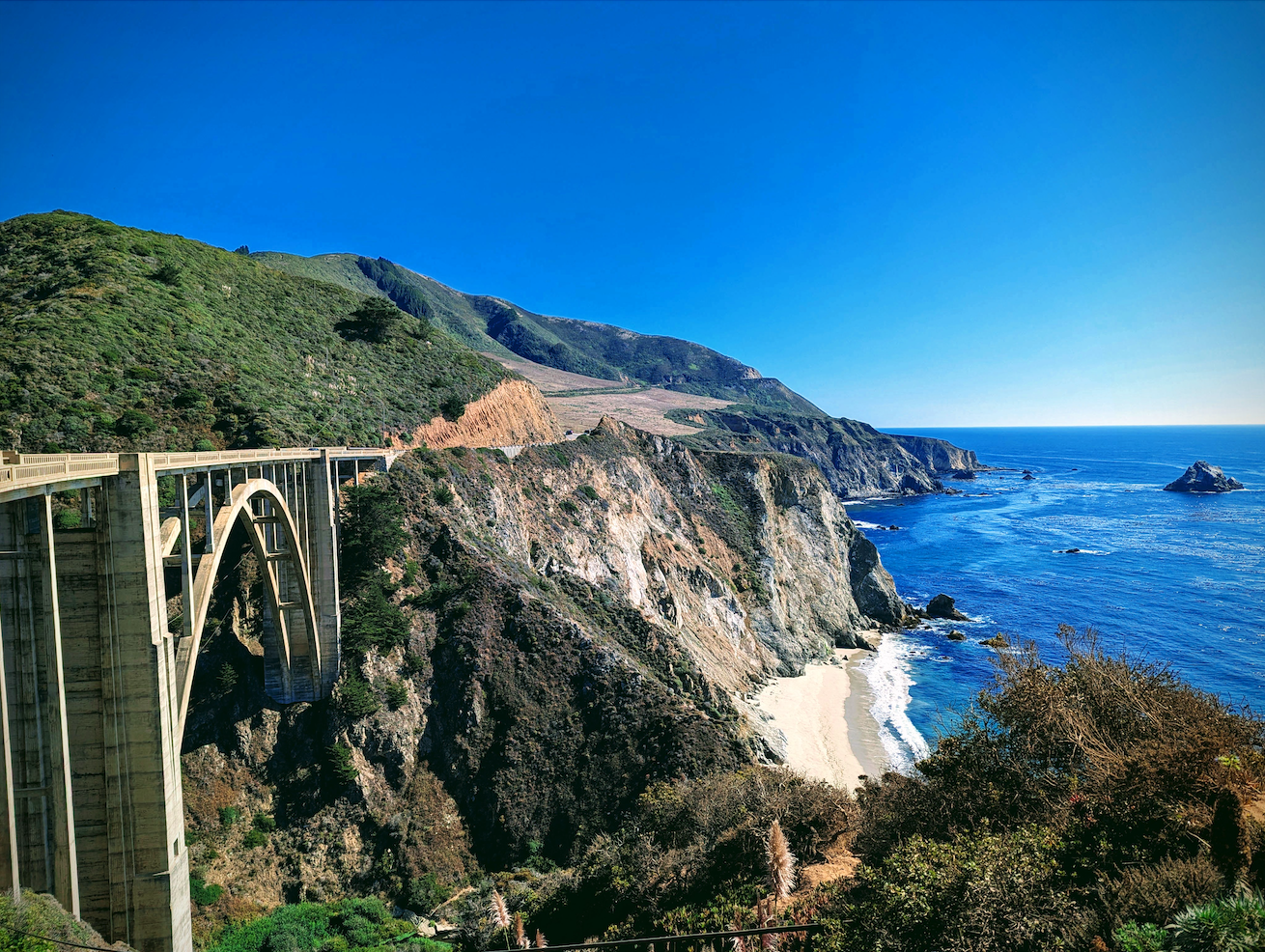 A picture of a high bridge, with ocean to the right side